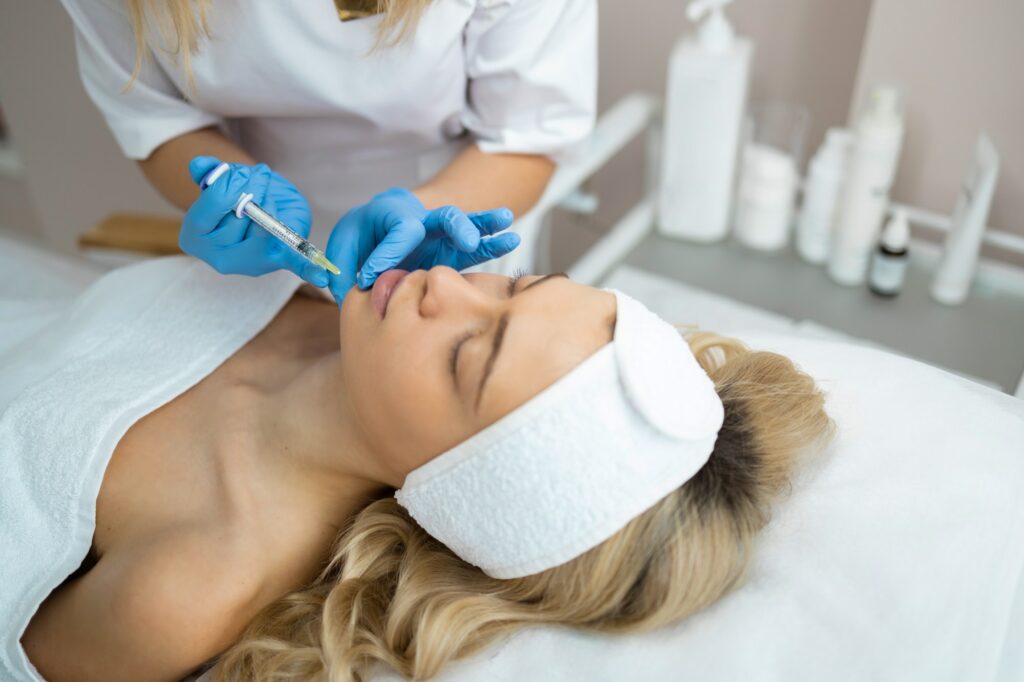Chin injection. Woman face during the beauty injection